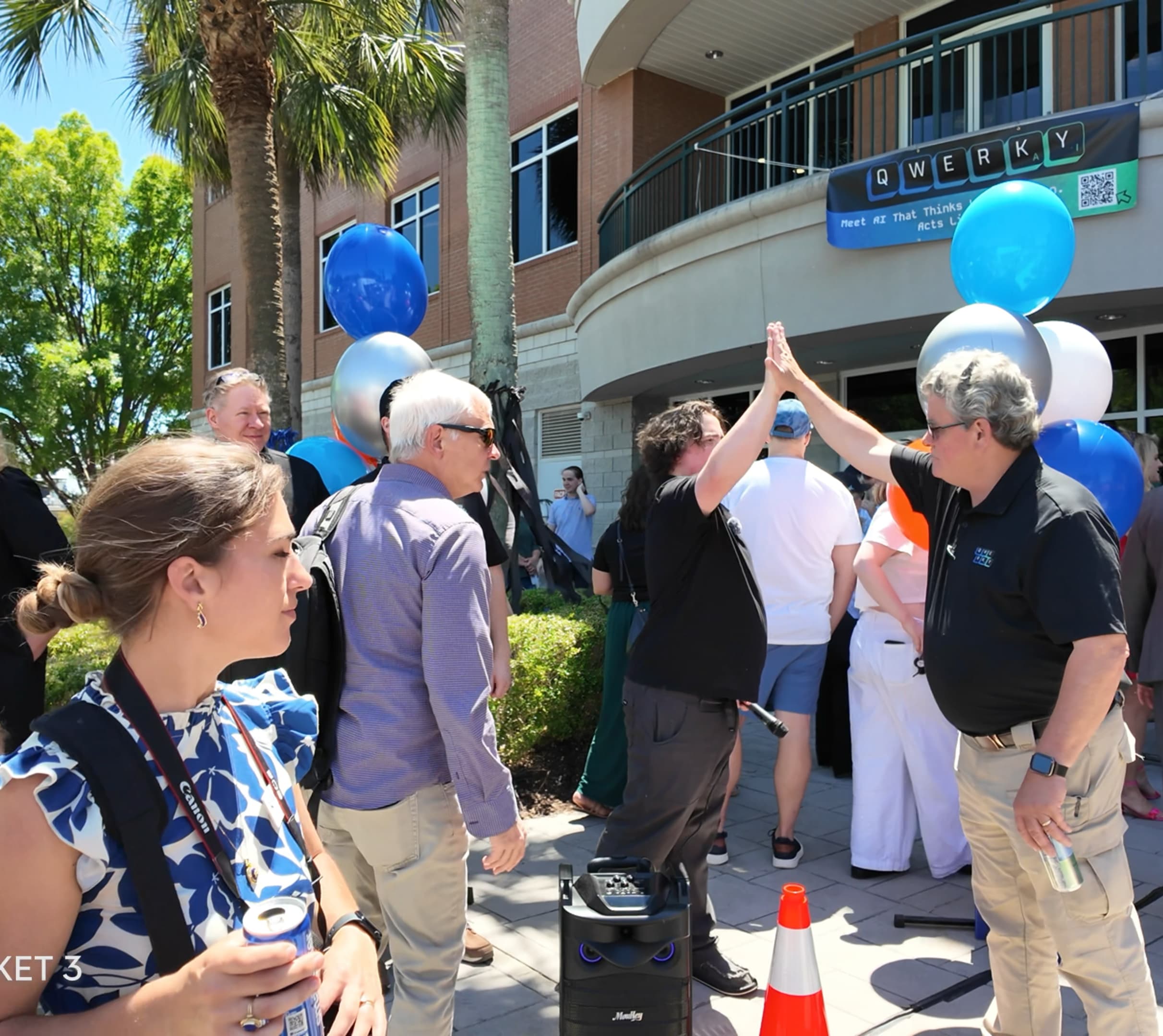 Co-founder Chris Thibault enjoys a high-five with his father as guests mingle post-ribbon-cutting